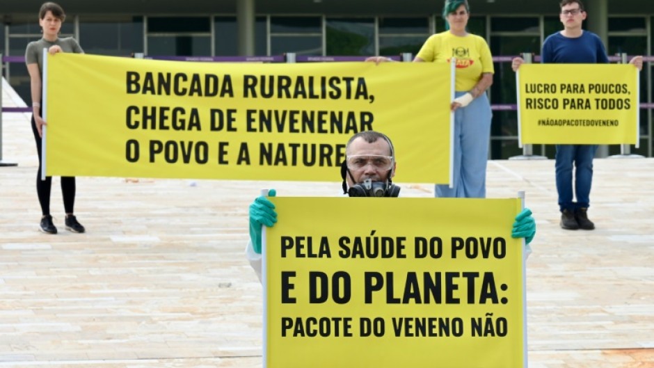 Members of an environmental group protest in front of the National Congress in Brasilia against the new pesticide law that eases the trade and use of these products, on October 4, 2023