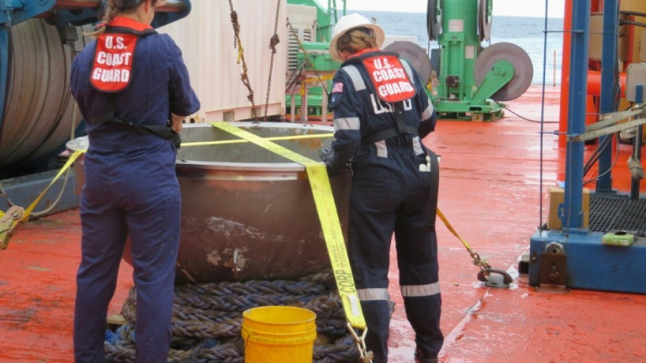 US Coast Guard engineers survey the recovered titanium endcap of the Titan sumbersible on October 1, 2023