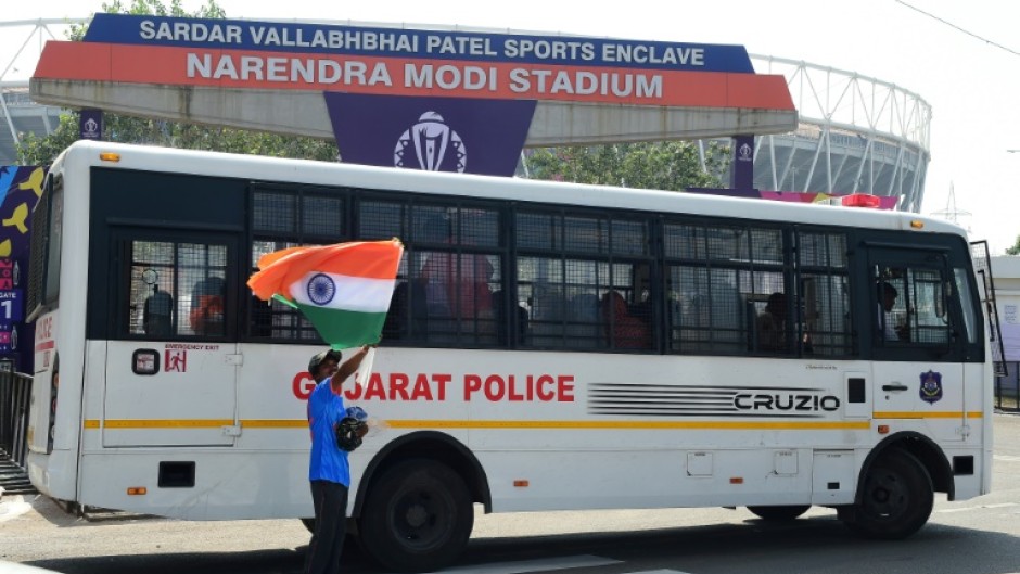 Flag day: A man selling Indian flags stands next to a police vehicle outside the Narendra Modi Stadium in Ahmedabad 