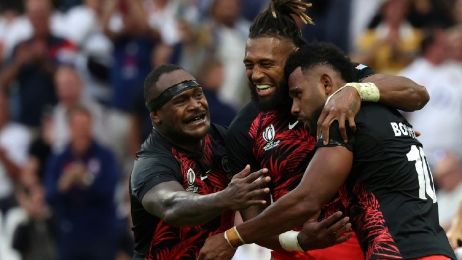 Fiji fly-half Vilimoni Botitu (right) celebrates scoring a try against England with captain Waisea Nayacalevu (centre) and flanker Levani Botia (left)