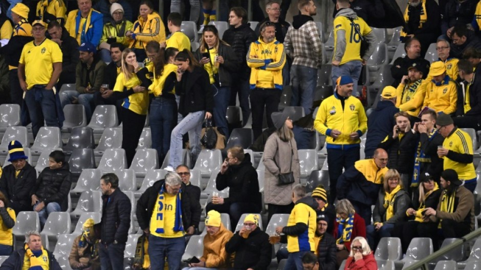 Sweden supporters wait inside the ground after their team's game against Belgium was stopped in the wake of an attack in Brussels