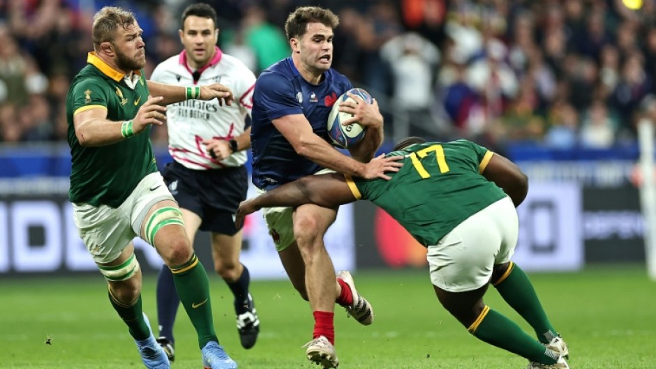 South Africa loose forward Duane Vermeulen (L) pursues France winger Damian Penaud (C) during the Rugby World Cup quarter-final in Paris.
