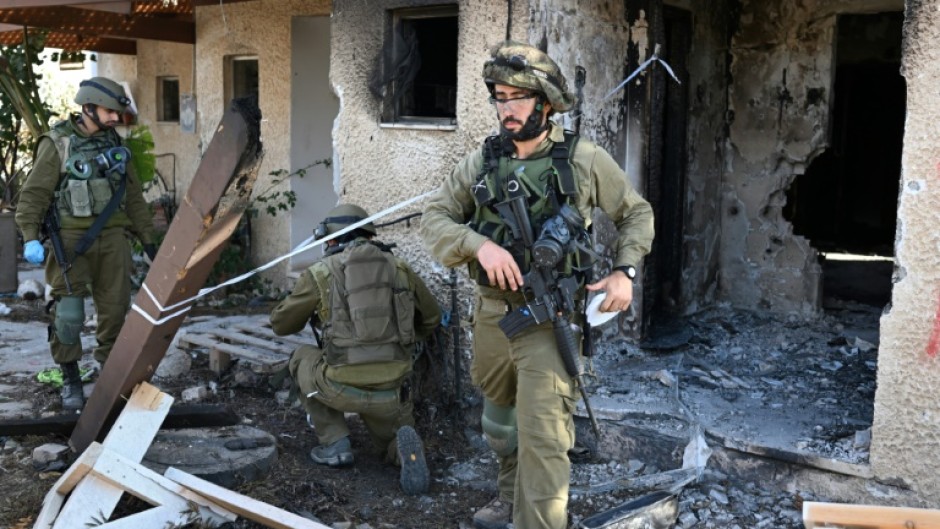 Israeli soldiers cordon off an area in Kibbutz Beeri near the border with the Gaza Strip on October 15, 2023, more than a week after the attack by Palestinian militants