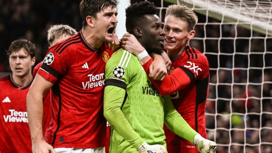 Manchester United's goal-scorer Harry Maguire (L) celebrates with Andre Onana after the goalkeeper's late penalty save against FC Copenhagen