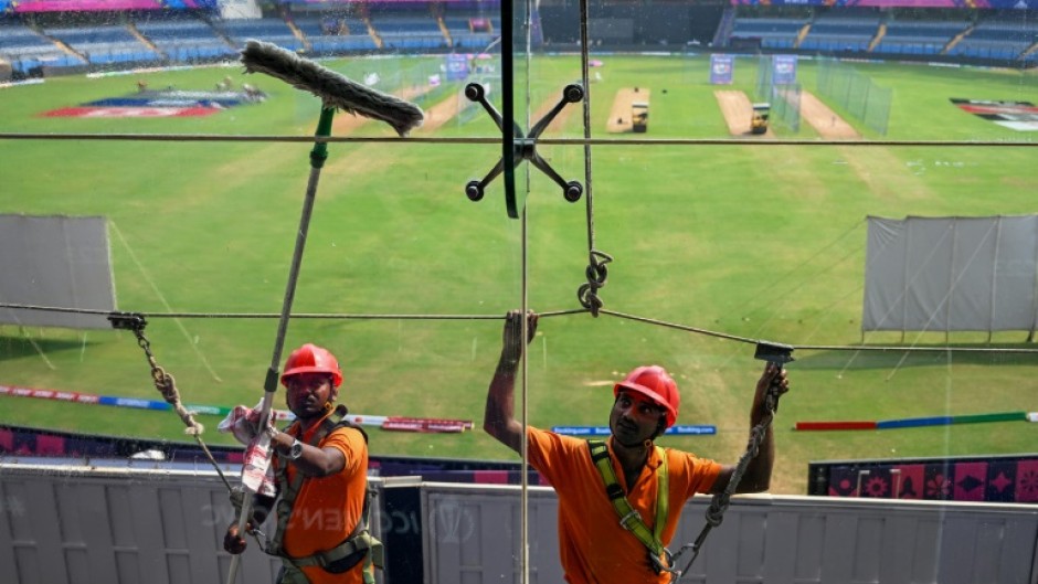 Point of view: Workers clean glass outside the media box at the Wankhede Stadium in Mumbai on Monday