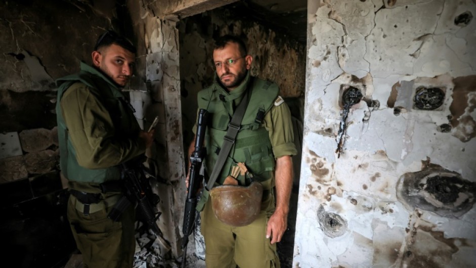 Israeli soldiers enter a home in Kfar Aza, one of the kibbutzim attacked by Palestinian Hamas militants on October 7