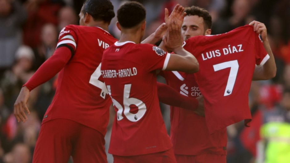 Liverpool forward Diogo Jota shows off a shirt with the name of forward Luis Diaz