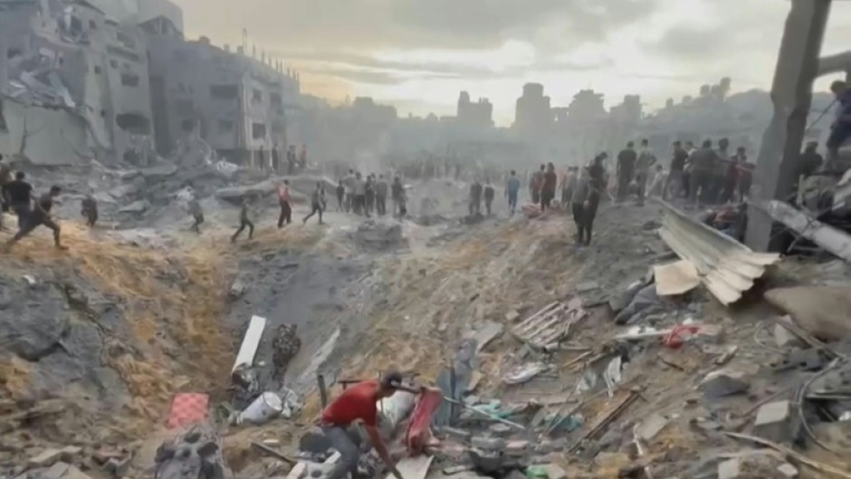 This image grab taken from AFPTV video footage shows Palestinians looking for survivors in a crater following a stike on a refugee camp in Jabalia on the northern Gaza Strip, on October 31, 2023