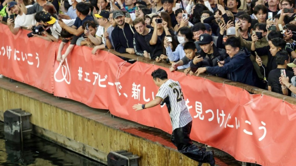 Fans of the Hanshin Tigers threw themselves into Osaka's Dotonbori River after the team won the Japan Series on Sunday