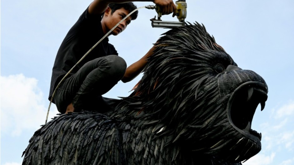 A worker fixes a King Kong statue made with old tyres at artist Mean Tithpheap's house in Cambodia