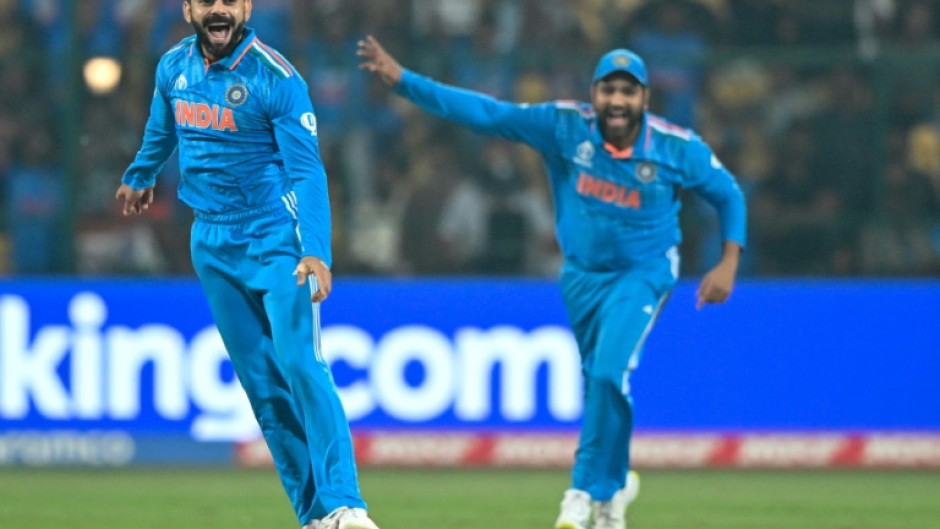 Rare moment: Virat Kohli celebrates with captain Rohit Sharma after taking the wicket of Scott Edwards 