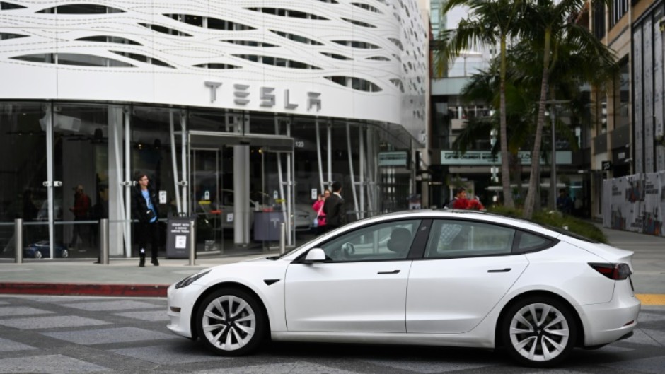 A Tesla electric vehicle drives past the Tesla Inc Santa Monica Place store, in Santa Monica, California