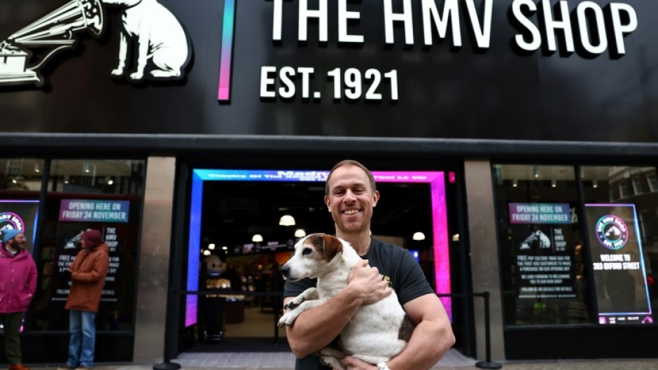 HMV owner Doug Putman holds his dog Ollie outside Oxford Street's famed store