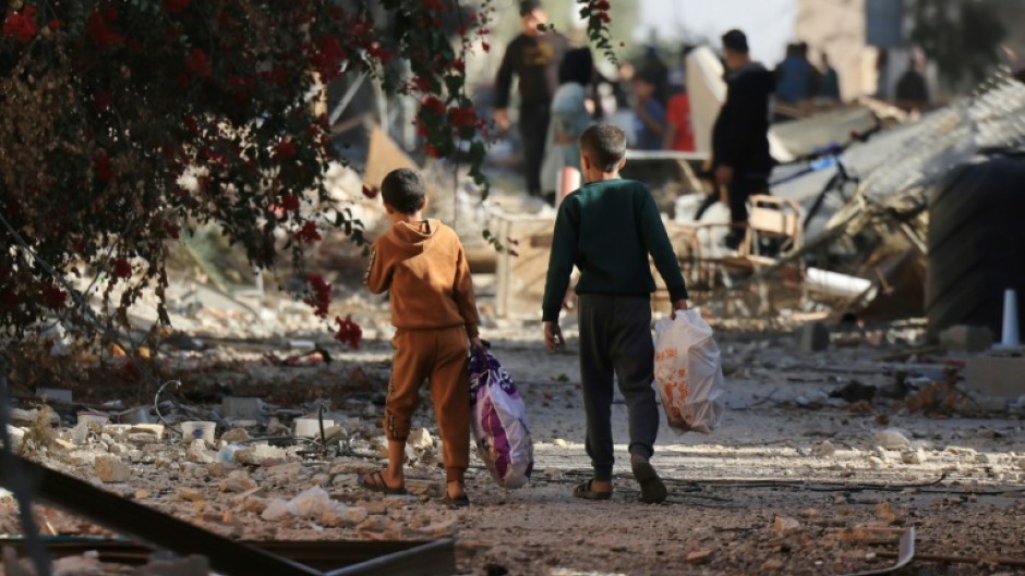 Palestinians return to the Khezaa district on the eastern outskirts of Khan Yunis