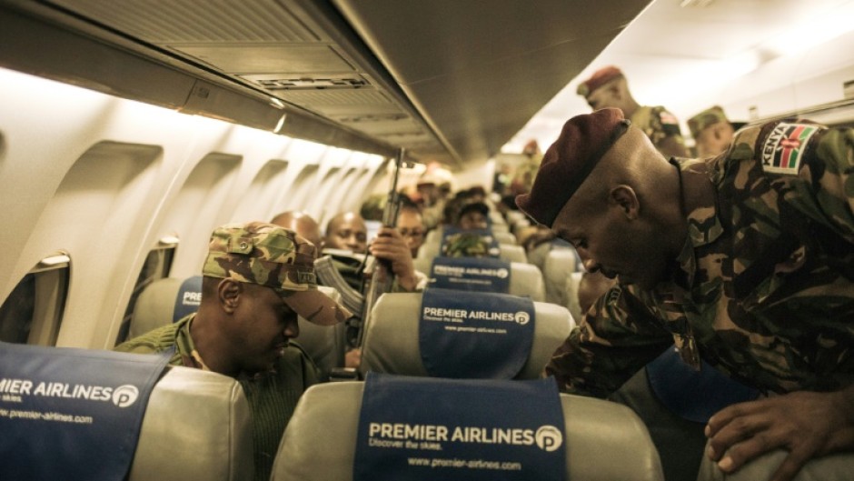 A first group of around 100 Kenyan soldiers from the East African Community regional force board a plane to leave the DRC