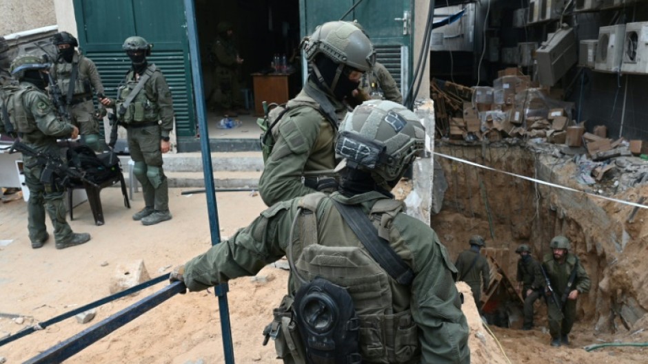 --PHOTO TAKEN DURING A CONTROLLED TOUR AND SUBSEQUENTLY EDITED UNDER THE SUPERVISION OF THE ISRAELI MILITARY-- Israeli troops surround what the army says is the entrance to a tunnel dug by Hamas militants inside the Al-Shifa hospital complex