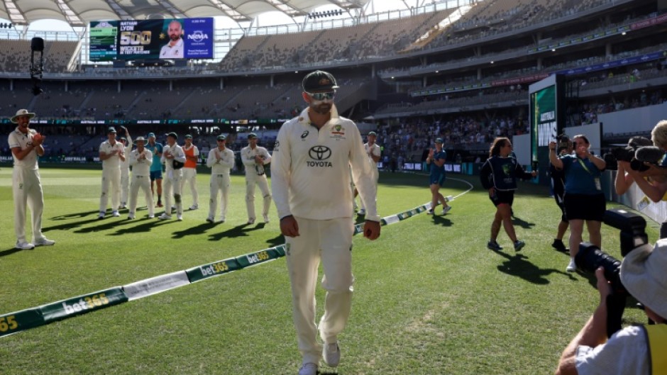 Australia's players applaud teammate Nathan Lyon (C) after he took his 500th Test wicket