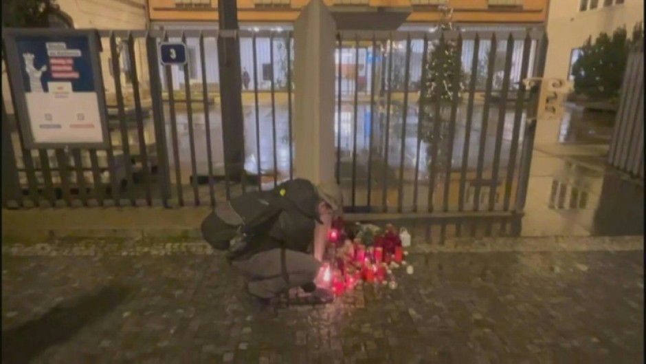 People light candles for victims of Prague shooting at makeshift memorial 