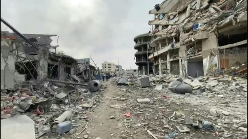 Palestinians walk along destroyed streets in Gaza City