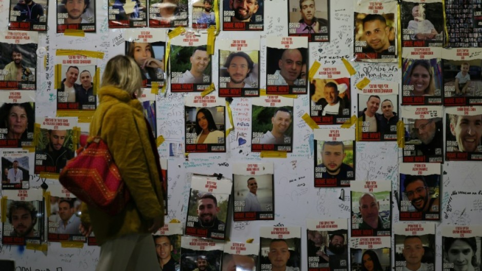 A woman looks at portraits of Israeli hostages on the sidelines of a rally calling for their release, in Tel Aviv