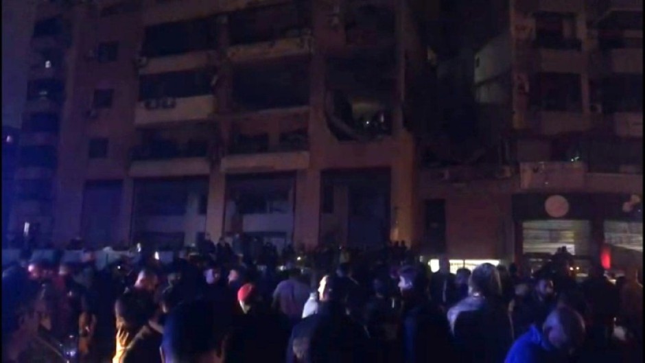 People gather in the street at site of explosion in Beirut's southern suburbs