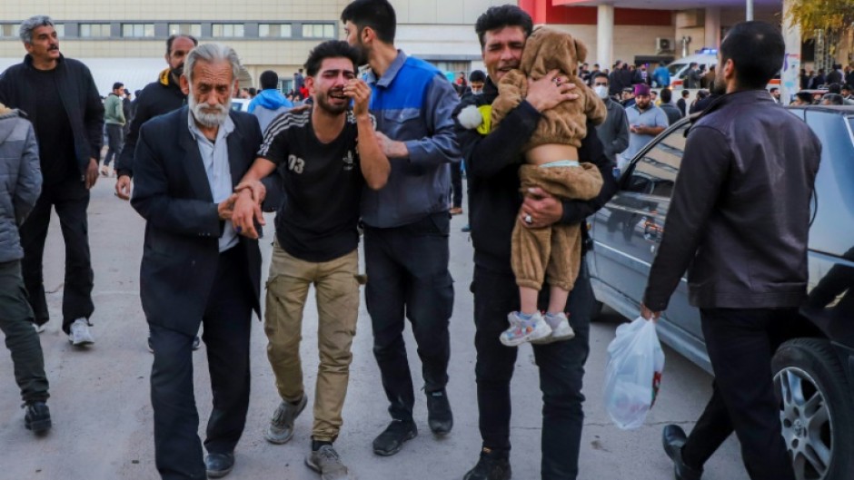 People injured in the explosions are helped outside a hospital in the southern Iranian city of Kerman on January 3, 2024