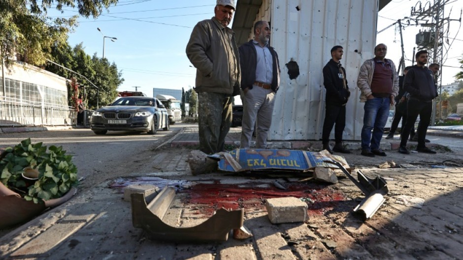 People look at a pool of blood where one six Palestinians was killed during an Israeli raid in Jenin, the occupied West Bank