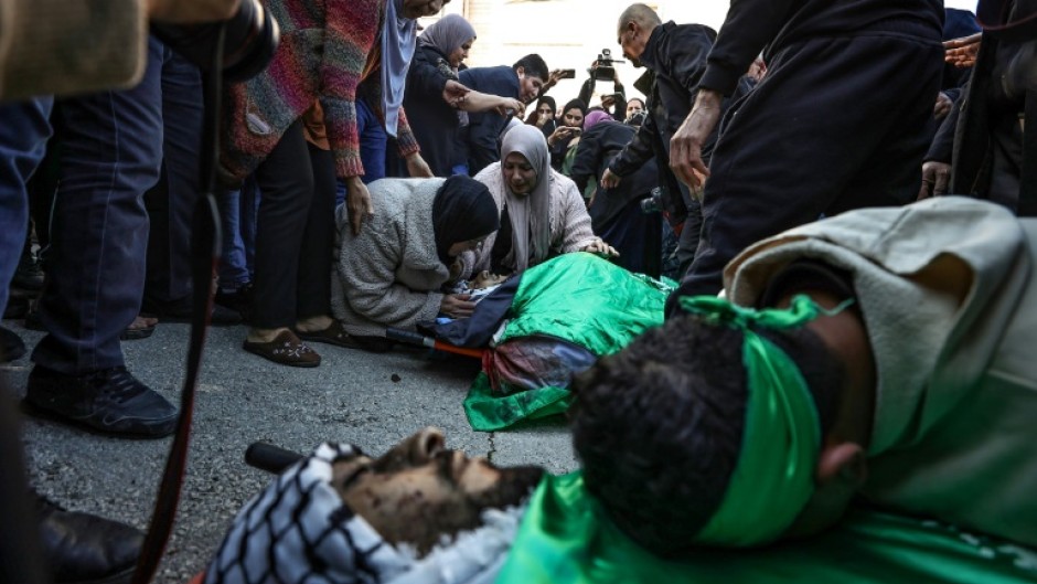 A relative mourns over a flag-draped body after several Palestinians were killed during an Israeli raid in Jenin, the occupied West Bank