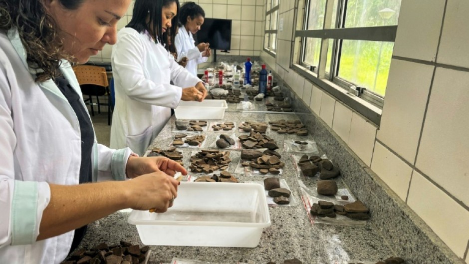 Archaeologists examine ceramic fragments found during excavations at the construction site of a complex of popular apartments in the city of Sao Luis, Brazil