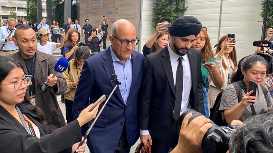 Singaporean transport minister S. Iswaran (centre L) leaves court after an appearance on Thursday