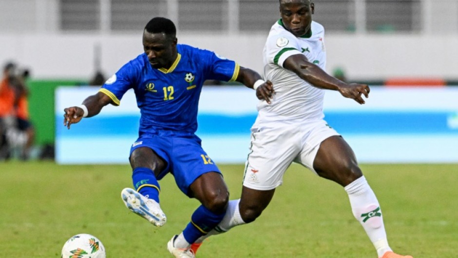 Simon Msuva (L) of Tanzania shields the ball from Lameck Banda of Zambia.
