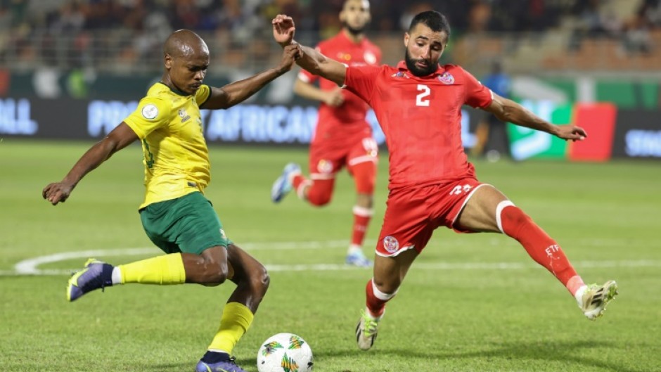 South Africa forward Percy Tau (L) crosses under pressure from Tunisia defender Ali Abdi
