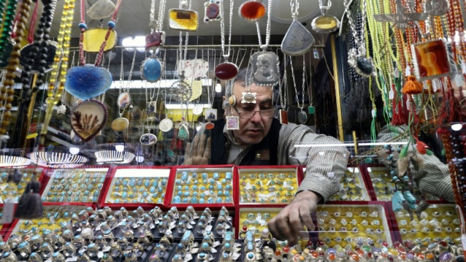 A seller displays stone rings at his shop in the city of Shahr-e Ray