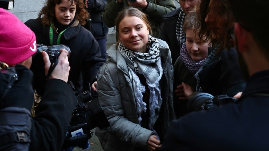 Swedish environmental activist Greta Thunberg (C) arrives with other activists at Westminster Magistrates Court in London for the first day of her trial