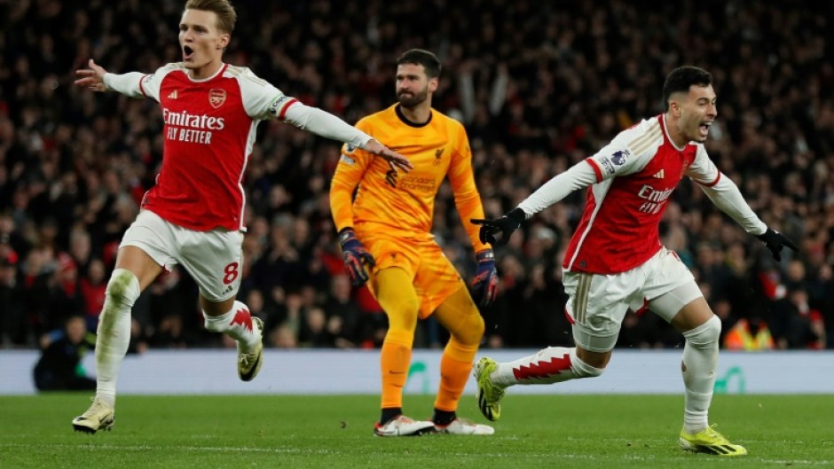 Arsenal's Gabriel Martinelli  (R) celebrates scoring after a mistake from Liverpool keeper Alisson Becker