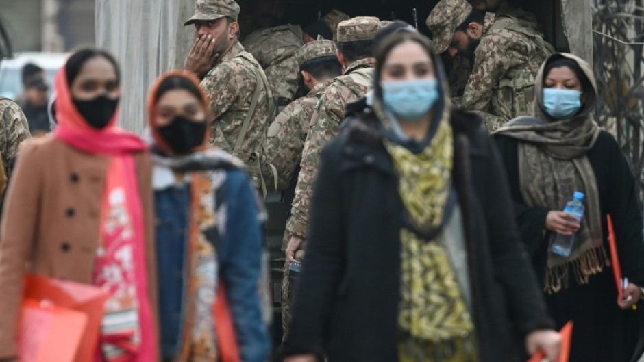 Pakistan army personnel watcs as election officials arrive at a polling station in Lahore