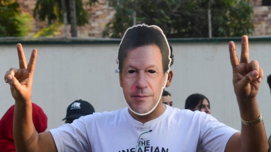 A man wearing a mask of jailed former Pakistan prime minister Imran Khan protests against alleged election rigging in Karachi 