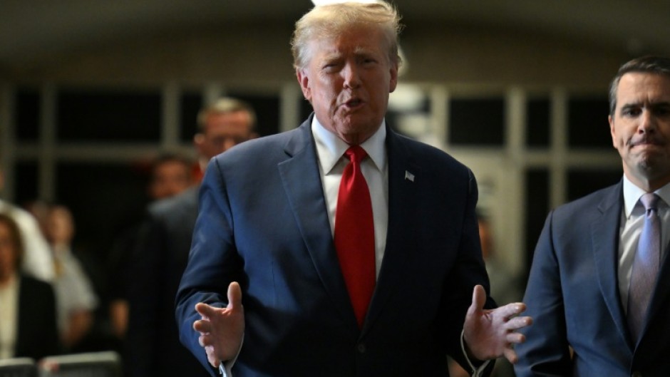 Former US President Donald Trump speaks to the press as he arrives at Manhattan Criminal Court for a hearing in his case of allegedly paying hush money to cover up an affair