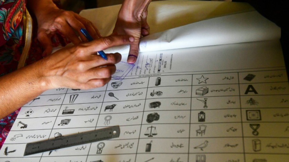 A woman marks a ballot paper with a fingerprint in Karachi during national and provincial elections in Pakistan last week