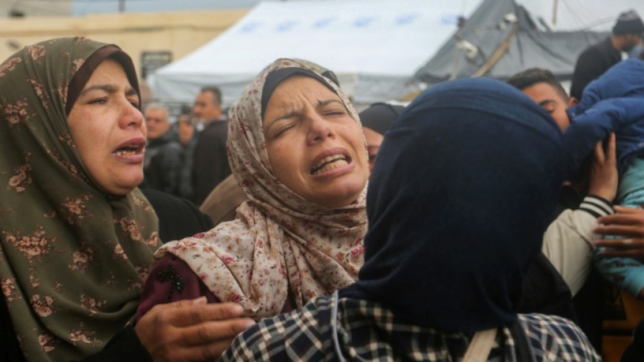 Palestinian women mourn the death of relatives in an Israeli air strike in Gaza's Deir al-Balah 