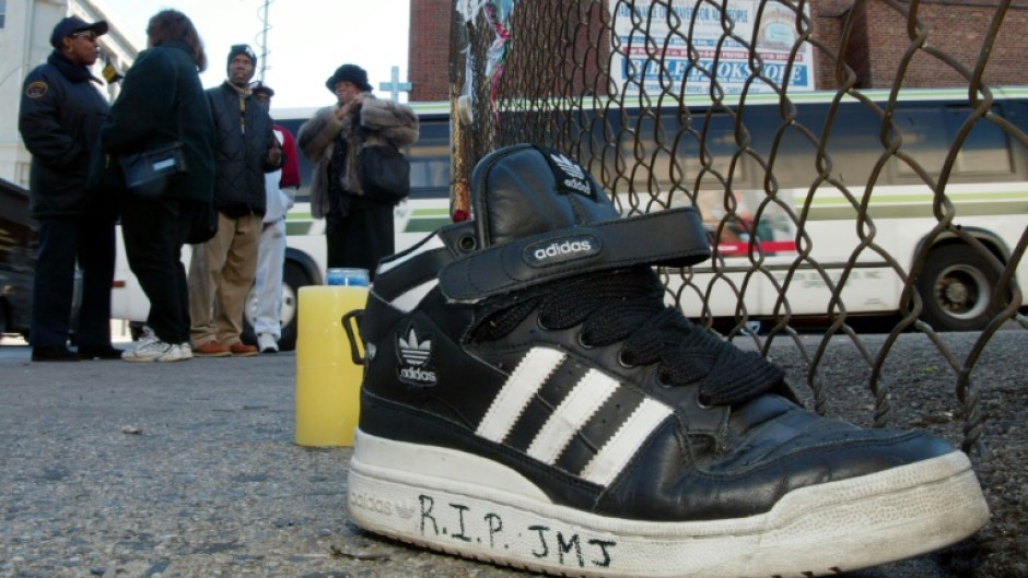 An Adidas sneaker bearing a mourner's message sits on the street outside the music studio in the Queens neighborhood where former Run-DMC member Jason Mizell, known as DJ Jam Master Jay, was shot dead