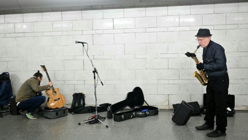 In an airy spot between two escalators a small group of musicians are unpacking their instruments, checking their music and calming any last minute nerves