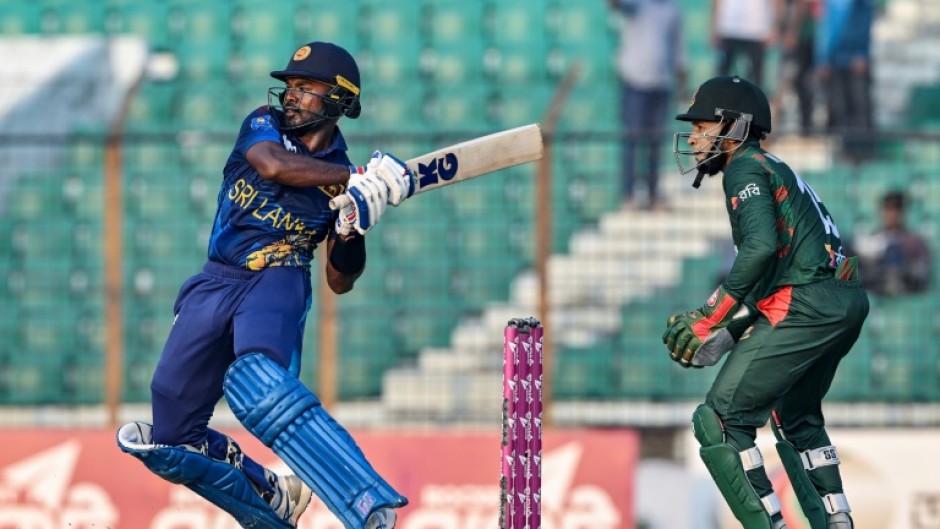 Sri Lanka's Janith Liyanage plays a shot as Bangladesh's Mushfiqur Rahim (R) watches during the first one-day international