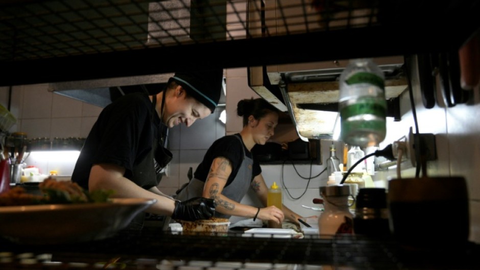 Agustina Bovi (L) cooks at the small vegan restaurant 'Yedra,' in Buenos Aires, but even with another job on the side she's living through her 'worst period from an economic point of view'