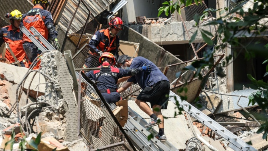 A Central News Agency photo shows emergency workers assisting a survivor after he was rescued from a damaged building in New Taipei City