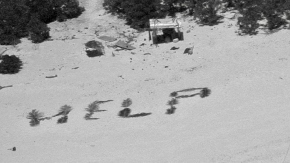 The 'HELP' sign made with palm fronds by three mariners stranded on a remote island in Micronesia is seen in an image obtained from the US Coast Guard