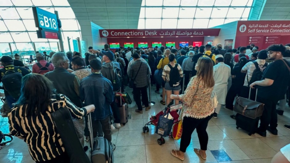 Passengers queue at a flight connection desk at Dubai airport