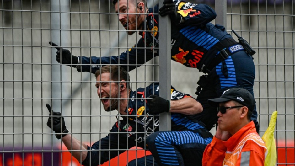 Red Bull team members celebrate on the pit wall as Max Verstappen wins