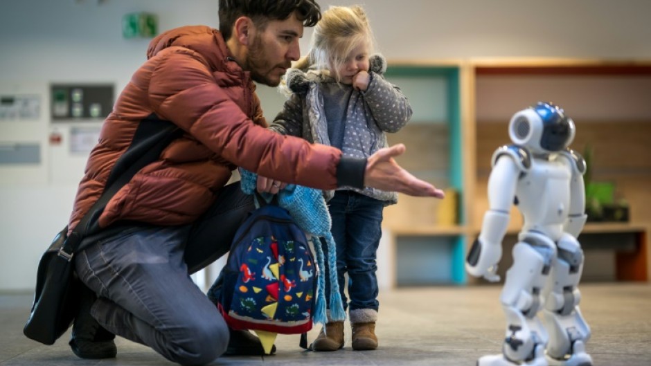 A father introduces his daughter to a robot called Nao in a Swiss creche  