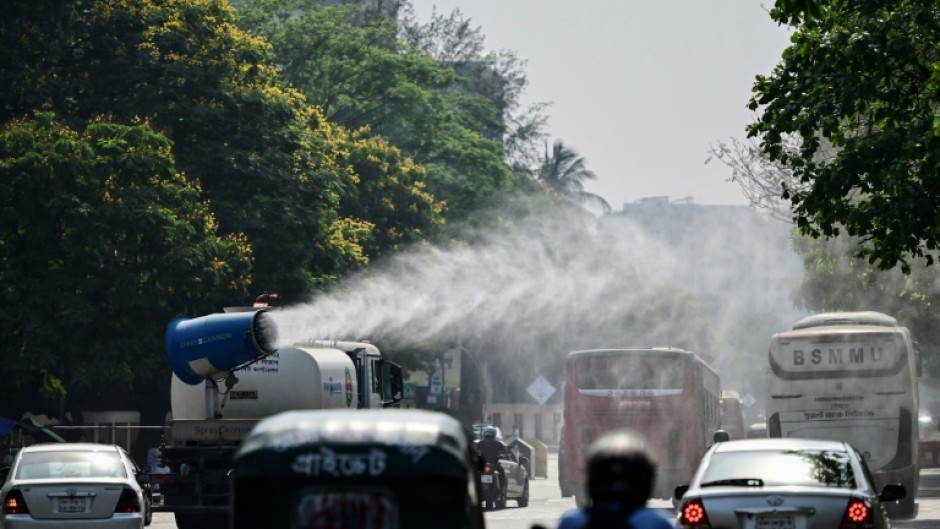 A vehicle of the Dhaka North City Corporation sprays water along a busy road to lower the temperature amidst a heatwave